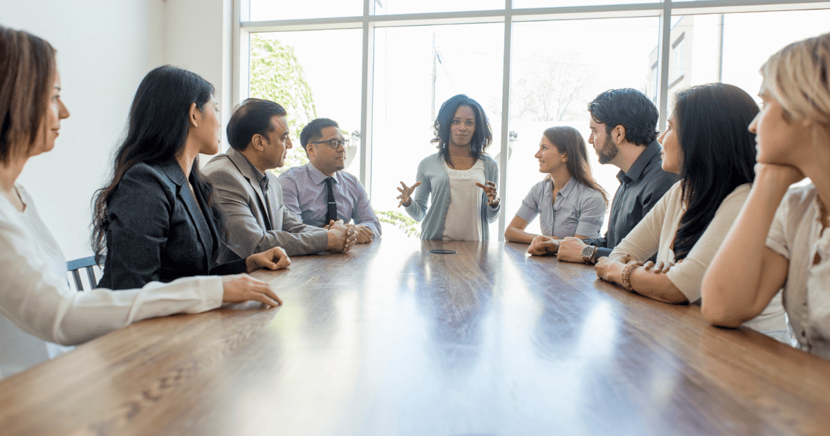 Diverse team in meeting discussing around table.